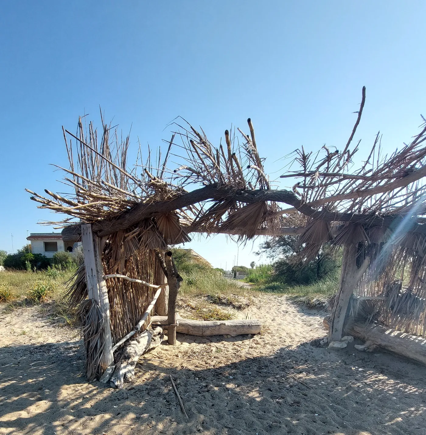 Struttura spontanea in legno e canne sulla spiaggia
