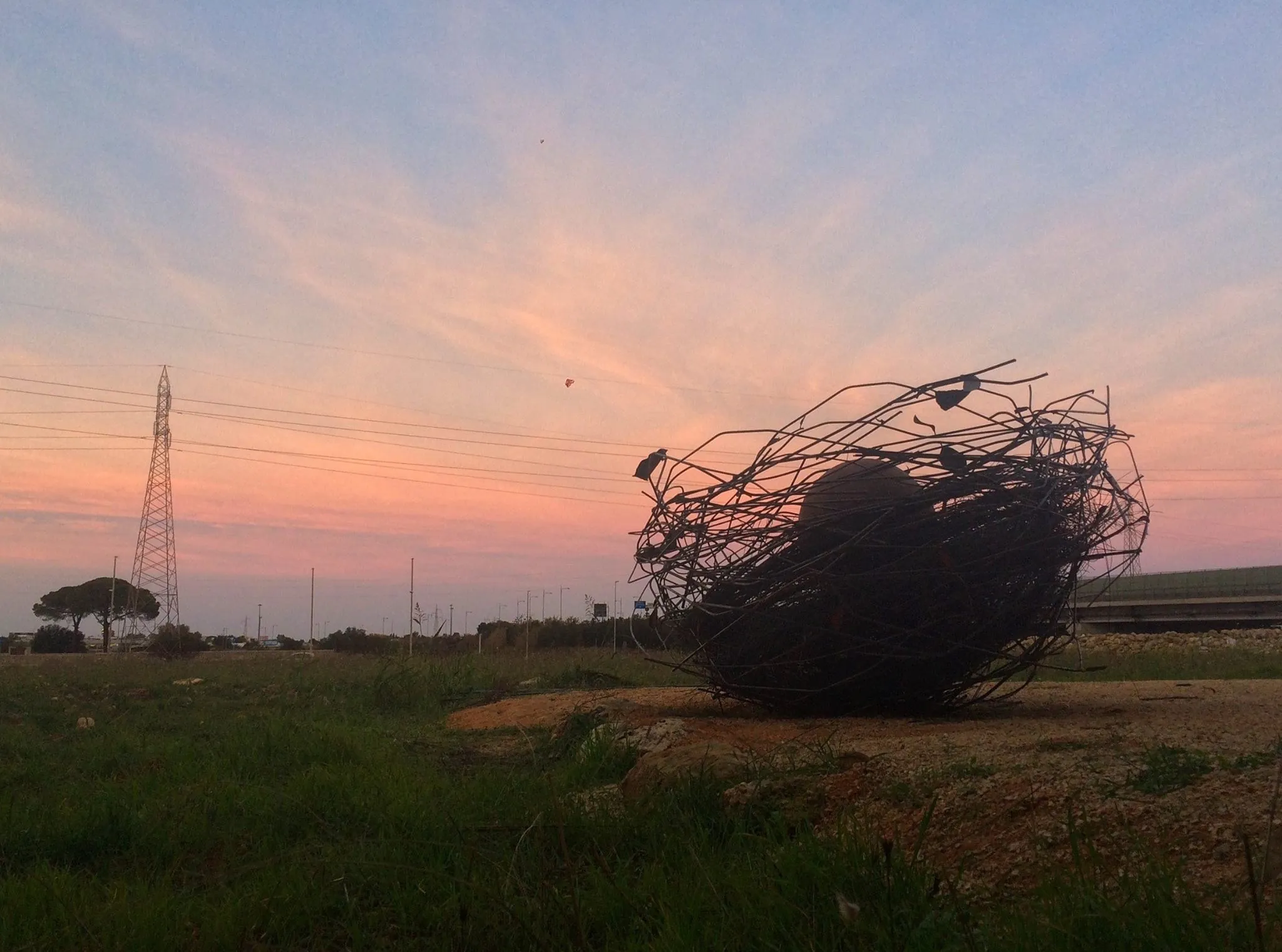 Uovo Cosmico nel paesaggio industriale al tramonto