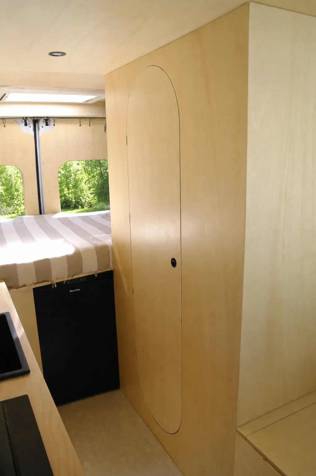Volume in legno del bagno con anta ovale chiusa