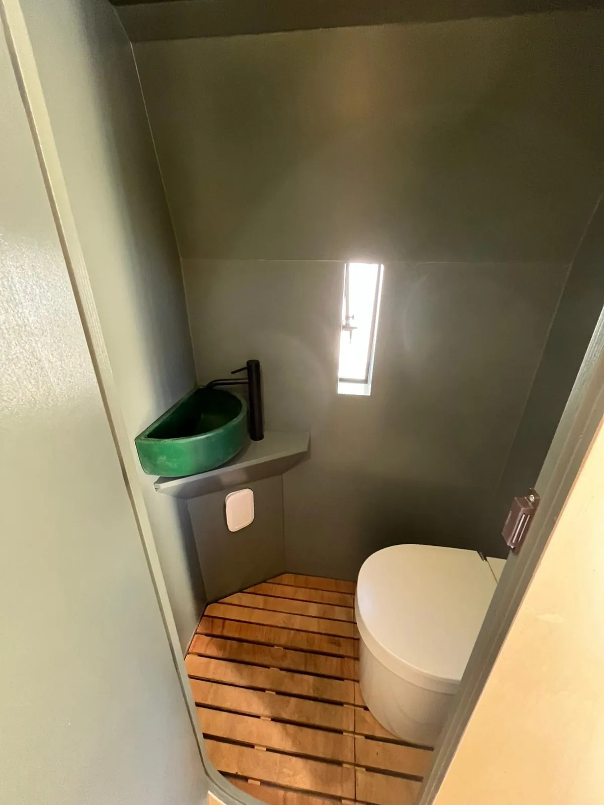 Bagno ultimato con lavabo verde e pedana in legno