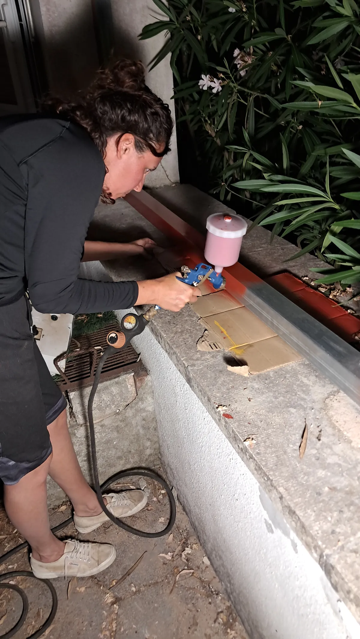 Lavorazione e verniciatura del telaio lungo il muro del giardino
